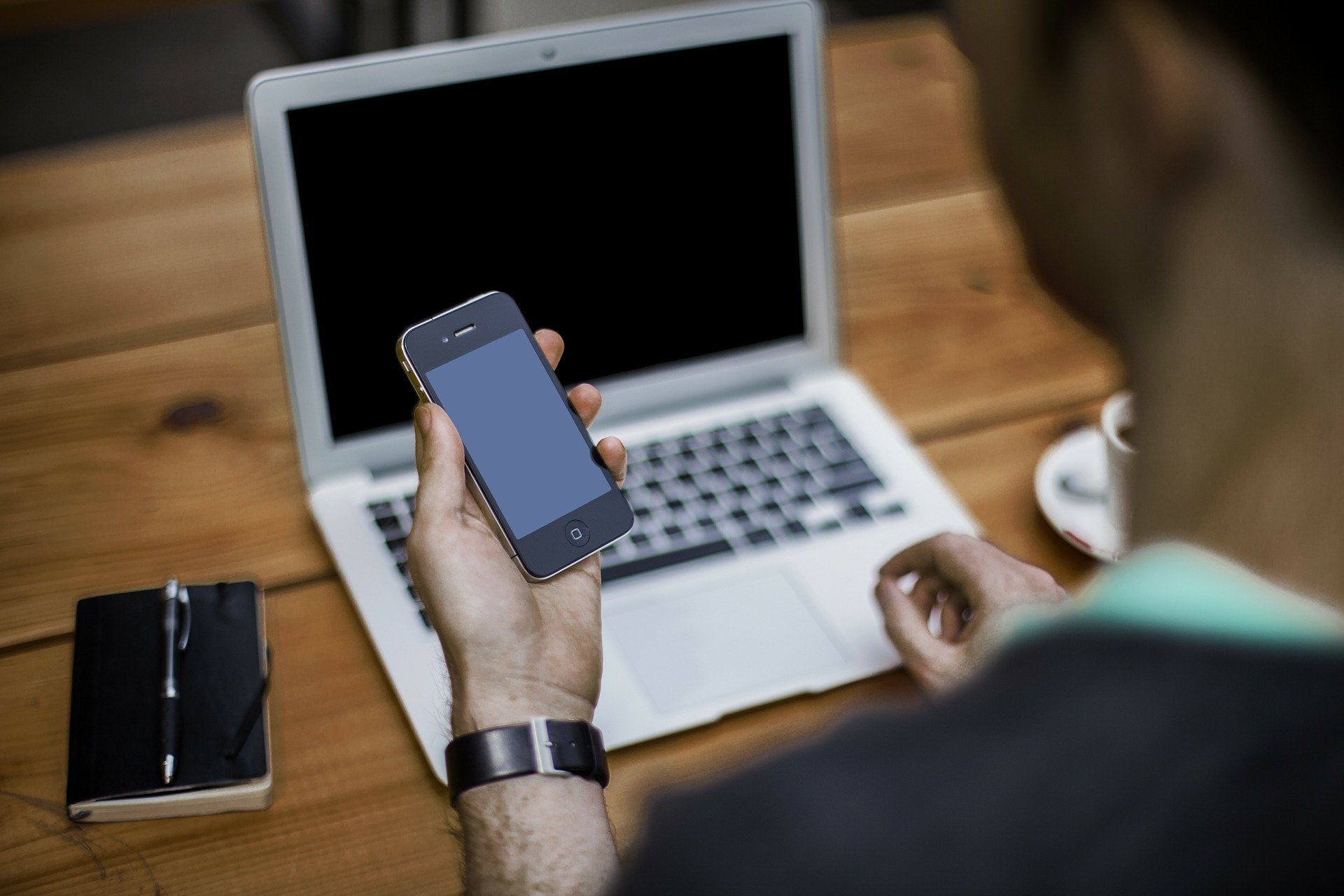 osoba trzymająca telefon komórkowy